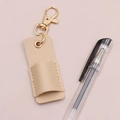 Dettaglio portapenne in pelle beige con moschettone dorato e anello in metallo lucido - 6.5*2.7cm / Albicocca