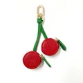 Detail of red cherry-shaped PU leather mini coin purse with golden lobster clasp and zipper - Cherry