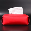 Modern red leather tissue box with metal snap buttons on a dark background - Red