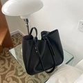 Close-up of black tote bag showing premium faux leather texture and knotted strap detail - Black