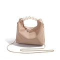 Detailed close-up of premium beige dumpling bag with pearl handle and gold chain strap - Khaki