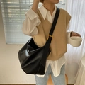 Minimalist black large hobo bag in grainy leather with gold buckle shown on a model - Black