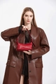 Detalle de bolso bandolera de cuero rojo con cremalleras laterales y correas decorativas - Burdeos