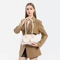 Detail of cream oil wax leather bowling bag featuring front flap pockets and silver hardware - White