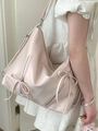 Pink bow tote bag with large capacity made of plain leather shown on a model - Pink
