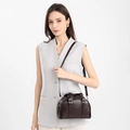 Detail view of deep chocolate brown Boston bag worn with adjustable shoulder strap - Dark Coffee