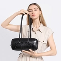 Detail of black glossy ballet-style underarm bag with decorative ribbon bows - Black