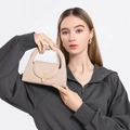 Minimalistische beige halve cirkel handtas met gouden draaislot gedragen door model - Khaki