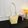 Minimalistische hellgelbe Eimertasche aus Kieselleder mit schlankem Schulterriemen - Gelb