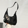 Minimalistische zwarte lederen hobo-tas met maanvorm en lange schouderriem in de hand gehouden - Zwart