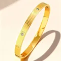 Elegant gold-plated stainless steel striped bangle featuring three inlaid zircon stones - Gold Brushed Triple Zirconia (47-B-6)