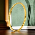 Primer plano de un anillo de acero inoxidable dorado facetado sobre madera oscura - US 5 / Dorado