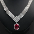 Macro detail of luxury oval ruby pendant necklace with diamond halo on silver chain - Lab-grown Ruby Style (NL024674-R)