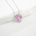 Macro-opname van een zilveren klavertje vier ketting met roze edelstenen op witte rots - 925 zilver / In het Lab Gekweekte Roze Saffier (NL024664-F)