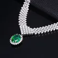 Macro shot of V-shaped S925 silver necklace with oval green garnet and pavé diamonds - Green Garnet Style (NL024674-G)