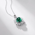 Macro shot of cushion-cut emerald pendant with sunburst diamond halo on silver chain - Lab-Grown Emerald