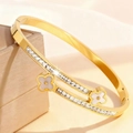 Detail van gouden klaverarmband met dubbele rijen vierkante diamanten op een doosje - Goud