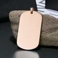 Gepolijste roségouden dog tag hanger van roestvrij staal staand op een grijze steen - Militaire Tag-Stijl (12-E-13) / Roségoud