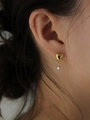 Gros plan de boucles d'oreilles cœur en argent 925 bicolore avec placage or et perle - Argent 925 / Or + Argent