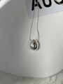 Close-up of a silver-toned teardrop pendant with a fine snake chain on a white tray - 925 Silver / Silver