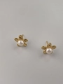 Primer plano de pendientes florales dorados con perlas blancas y pétalos texturizados - Dorado