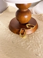 Dettaglio di orecchini a cerchio dorati geometrici con trama a filo su base in legno - Oro