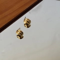 Macro view of gold 925 silver stud earrings with polished twisted croissant design - Gold
