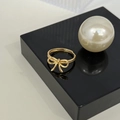 Makroaufnahme eines verstellbaren 18K Gold-Schleifenrings auf einem schwarzen Display - Gold