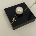 Dettaglio della collana in argento 925 dorato con ciondolo a fiocco e strass incastonati - Oro