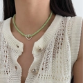 Handmade light green beaded necklace with interlaced silver heart pendants on model - Green + Heart