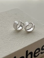 Macro detail of brushed silver hoops with matte texture on a white display surface - Silver