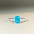 Macro shot of oval blue gemstone ring with micro-paved band in silver setting - Blue Paraiba With Inclusion-CBJZ512
