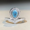 Macro shot of pear shaped aquamarine ring with V-shaped pavé band detail - US 5 / Blue Zirconia (CBJZ374)
