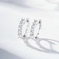 Dettaglio di orecchini a cerchio in argento sterling S925 con moissanite a quattro griffe - Argento 925 / Colore Platino (MS055)