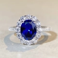 Macro shot of oval blue sapphire ring with brilliant halo diamonds in S925 silver - US 5 / Dark Blue Rhinestone