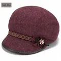 Détail d'un béret rouge foncé montrant la texture tweed et le ruban fleuri avec rose en métal - Réglable 57-59cm / Rouge foncé