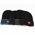 Vue détaillée de quatre bonnets d'hiver en bleu marine, anthracite, gris et bordeaux à étiquettes - Élastique 57-59cm / Étiquette en Plastique Sport