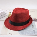 Classic red woven straw jazz fedora hat with black ribbon band on minimalist background - Burgundy