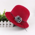 Detail of red faux mink fur hat with black decorative band and side flower accent - Medium (57-58cm) / Red with Rope Trim