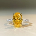 Macro shot of 5 carat yellow oval cut high carbon diamond ring with silver four-claw setting - US 5 / Yellow