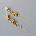 Dettaglio degli orecchini a foglia dorata con nappe e pietre a goccia brillanti - Oro