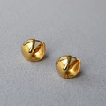 Macro view of chunky golden teardrop hoop earrings with a polished mirror finish - Gold