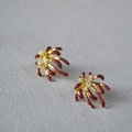 Vue macro de boucles d'oreilles en laiton doré avec émail rouge et petits zircons - Boucles d'Oreilles Clous Feu d'Artifice