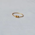 Primo piano di un anello in ottone placcato oro con doppia perla su tessuto grigio - US 5 / Oro