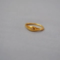 Anello dorato con stella polare e zircone centrale su sfondo di tessuto grigio - US 6 / Oro
