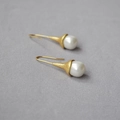 Retro matte gold long hook earrings with white pearls on a textured grey cloth background - Matte Light Gold Artificial Pearl Style (MYE0157-WG)