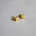 Macro detail of geometric gold-plated stud earrings with irregular hammered texture surface - Cube
