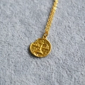 Detail of vintage gold coin necklace featuring Libra zodiac relief and hammered texture - Libra