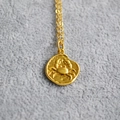 Macro view of a vintage golden coin pendant featuring a relief crab zodiac design - Cancer
