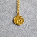 Nahaufnahme der goldenen Vintage-Halskette mit Widder-Relief und gebürsteter Metalltextur - Widder